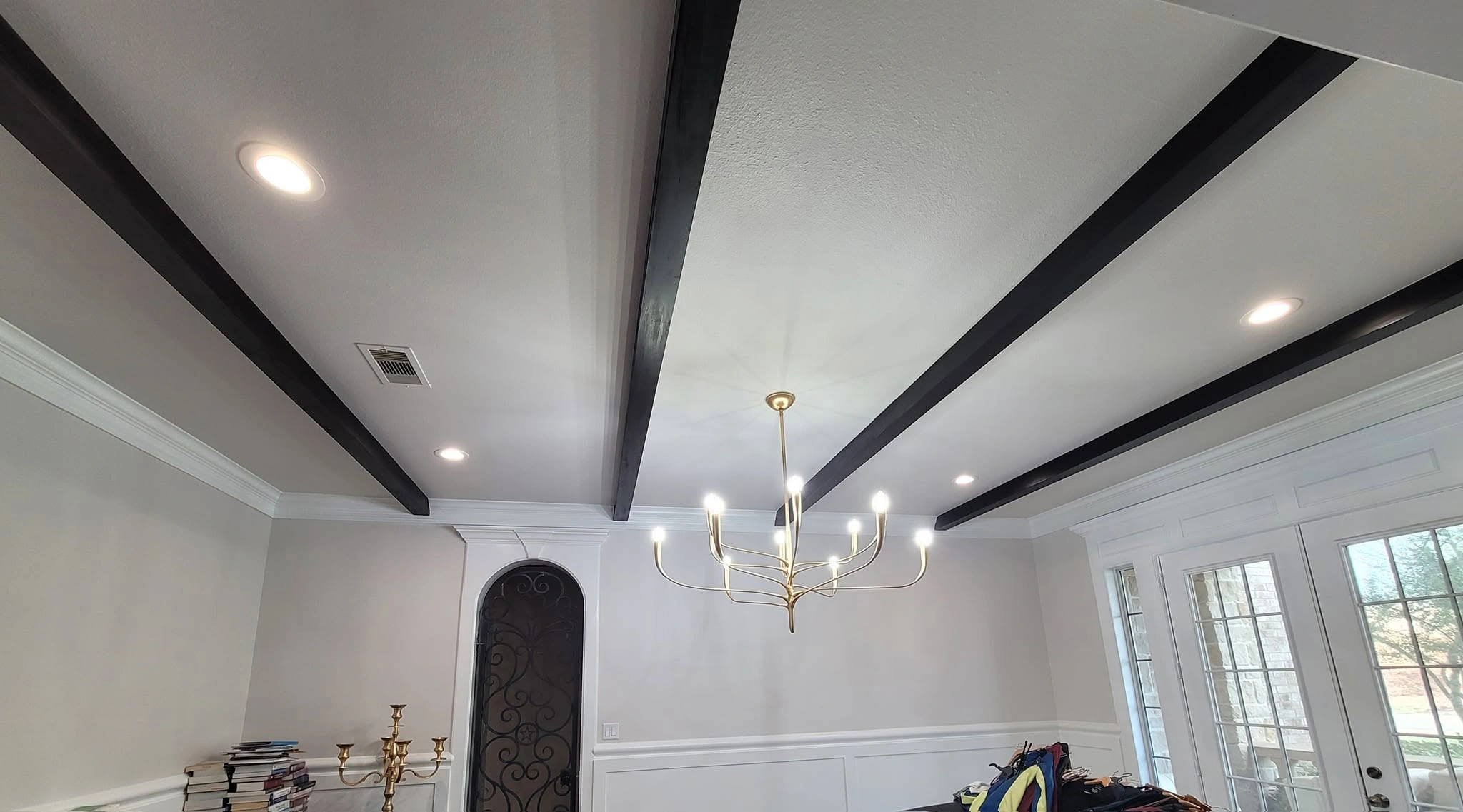 Modern chandelier and exposed beam ceiling lighting installed by an electrician in Richmond TX