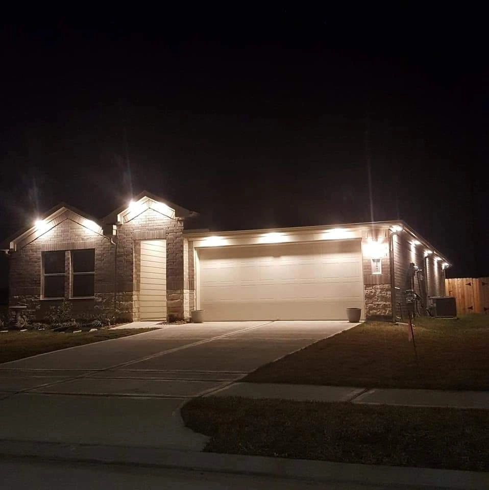 Exterior architectural soffit lighting and garage illumination installed on a home in Richmond TX